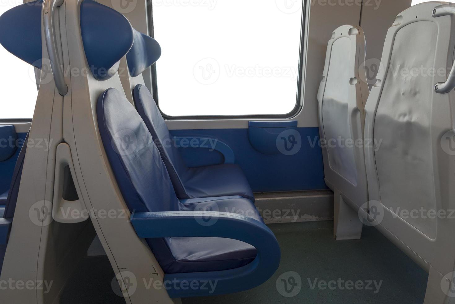 Inside the cab of the modern Express. Nobody in blue chairs by the window. Fuzziness. Comfortable chairs and table in the foreground, white background outside the window. photo