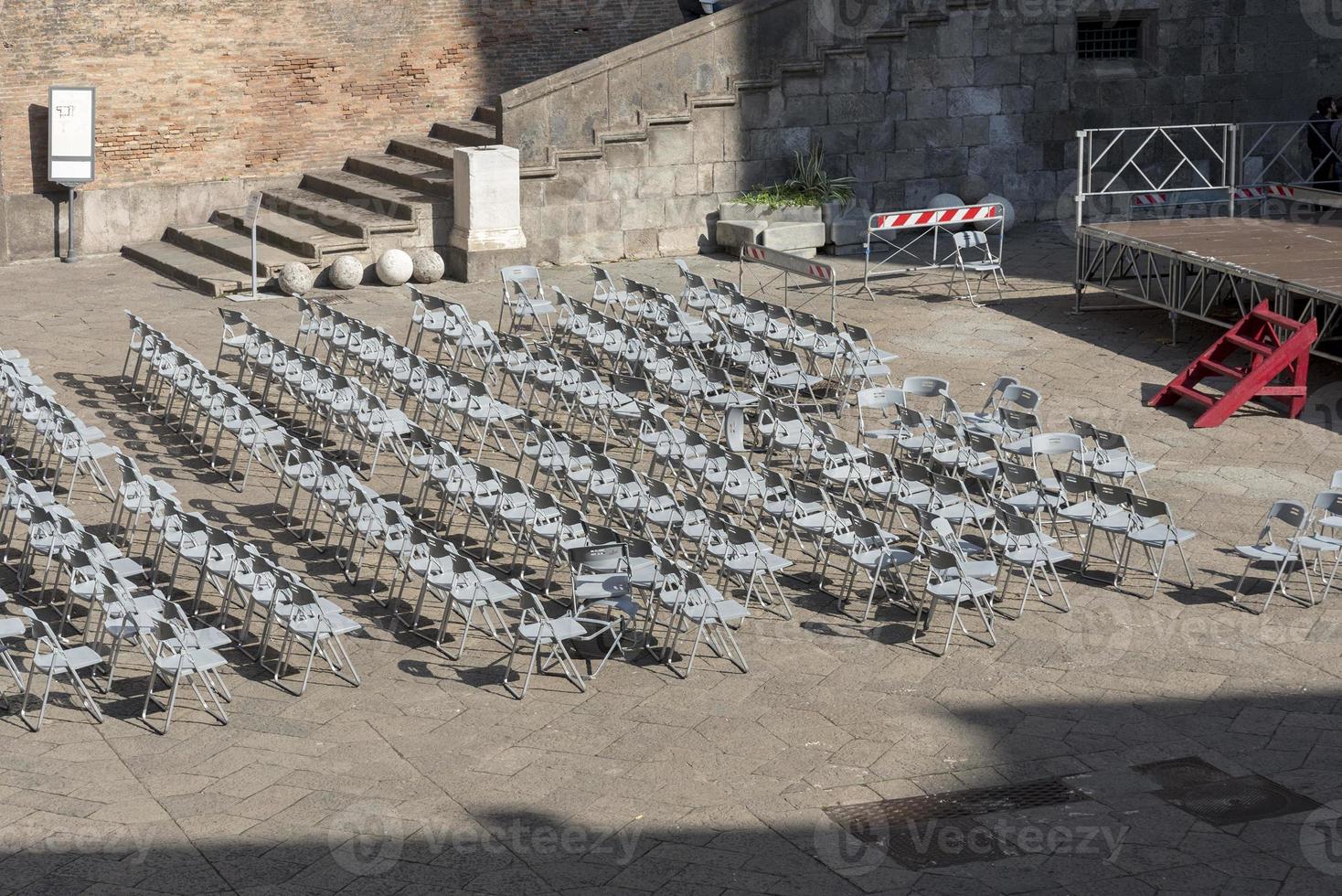 Lots of plastic chairs near the stage. photo