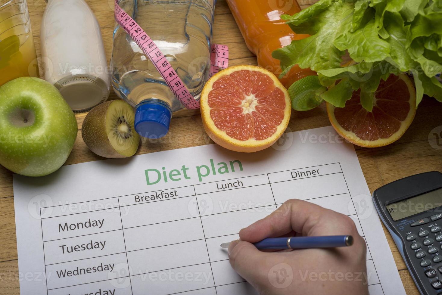 Diet plan, tape measure, water, diet of fresh fruits on the wooden floor. photo