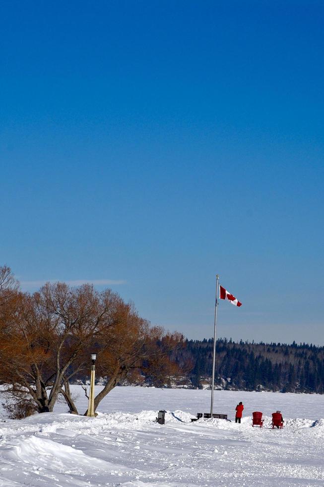 invierno en manitoba - dos sillas rojas con vistas a un lago congelado foto