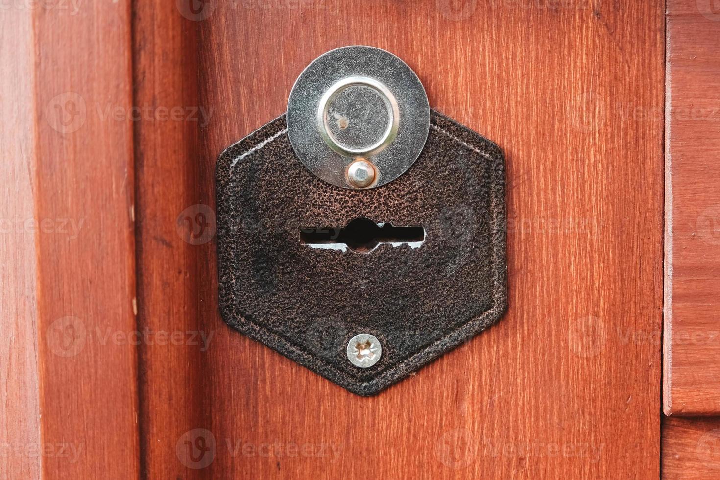 Metal hole for an old key in a wooden door. Copy, empty space for text photo