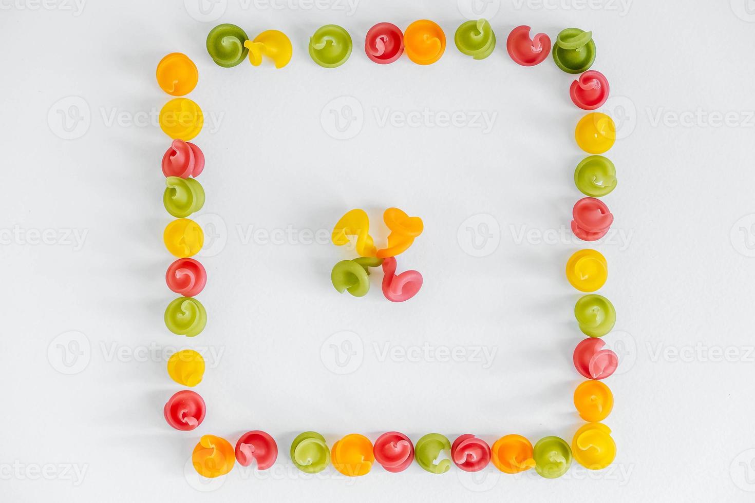 Multicolored pasta in the shape of a square on a white background photo