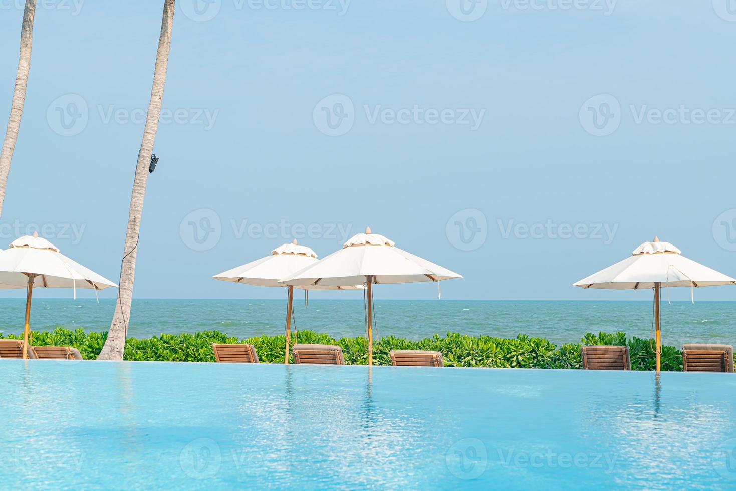 umbrella with bed pool around swimming pool with ocean sea background