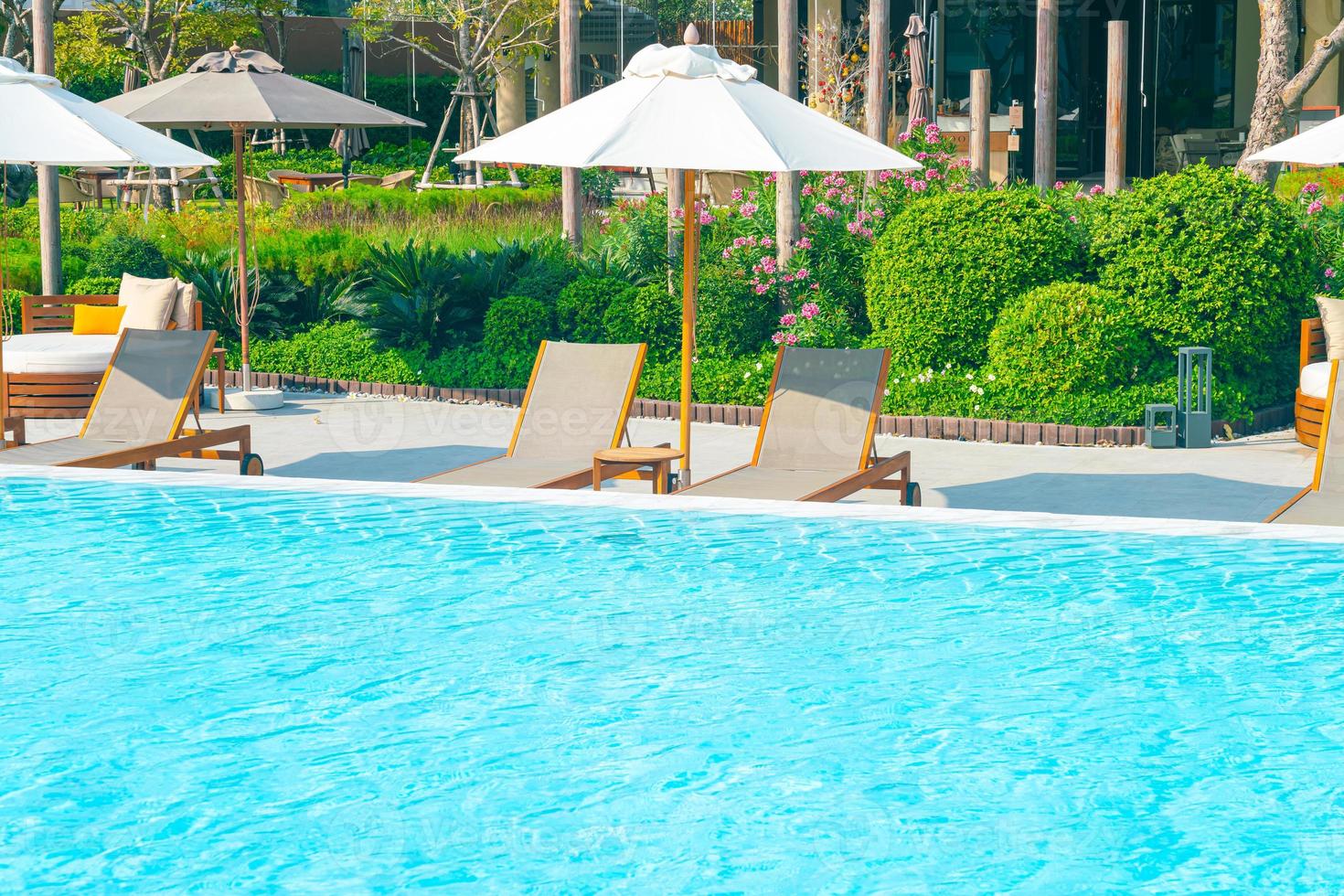 sombrilla con cama piscina alrededor de la piscina con fondo de mar océano foto