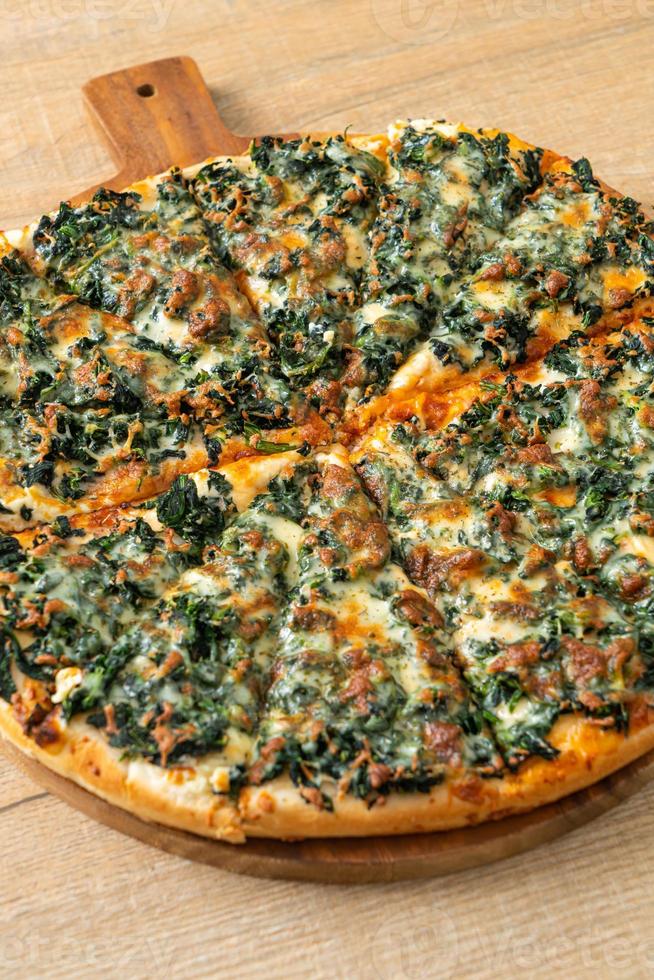 spinach and cheese pizza on wood tray photo