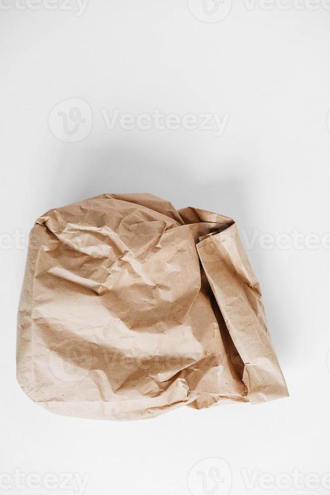 Full crumpled disposable bag of brown kraft paper on a white background. Top view. Copy, empty space for text photo
