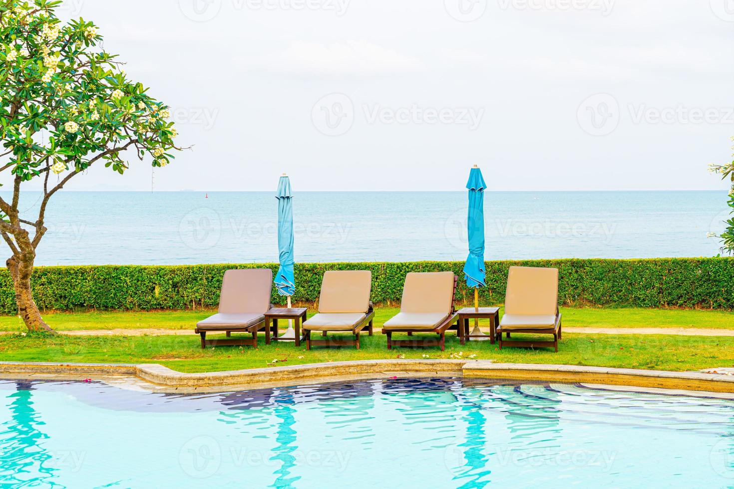 chair pool with umbrella around swimming pool photo