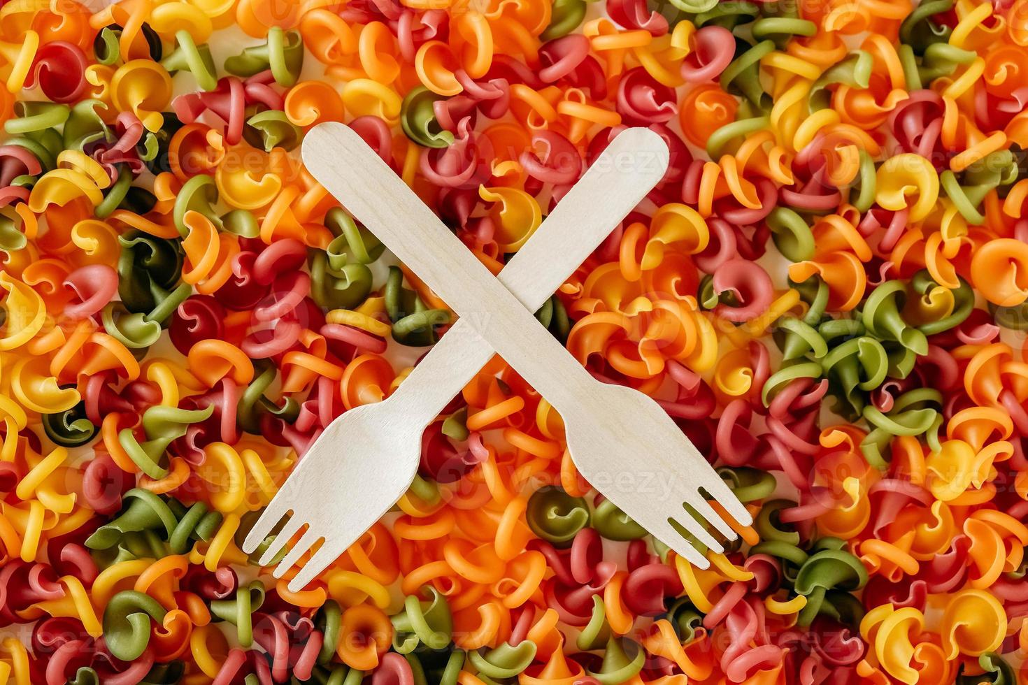 Multicolored pasta with a wooden forks as a background image. Top view. Copy, empty space for text photo