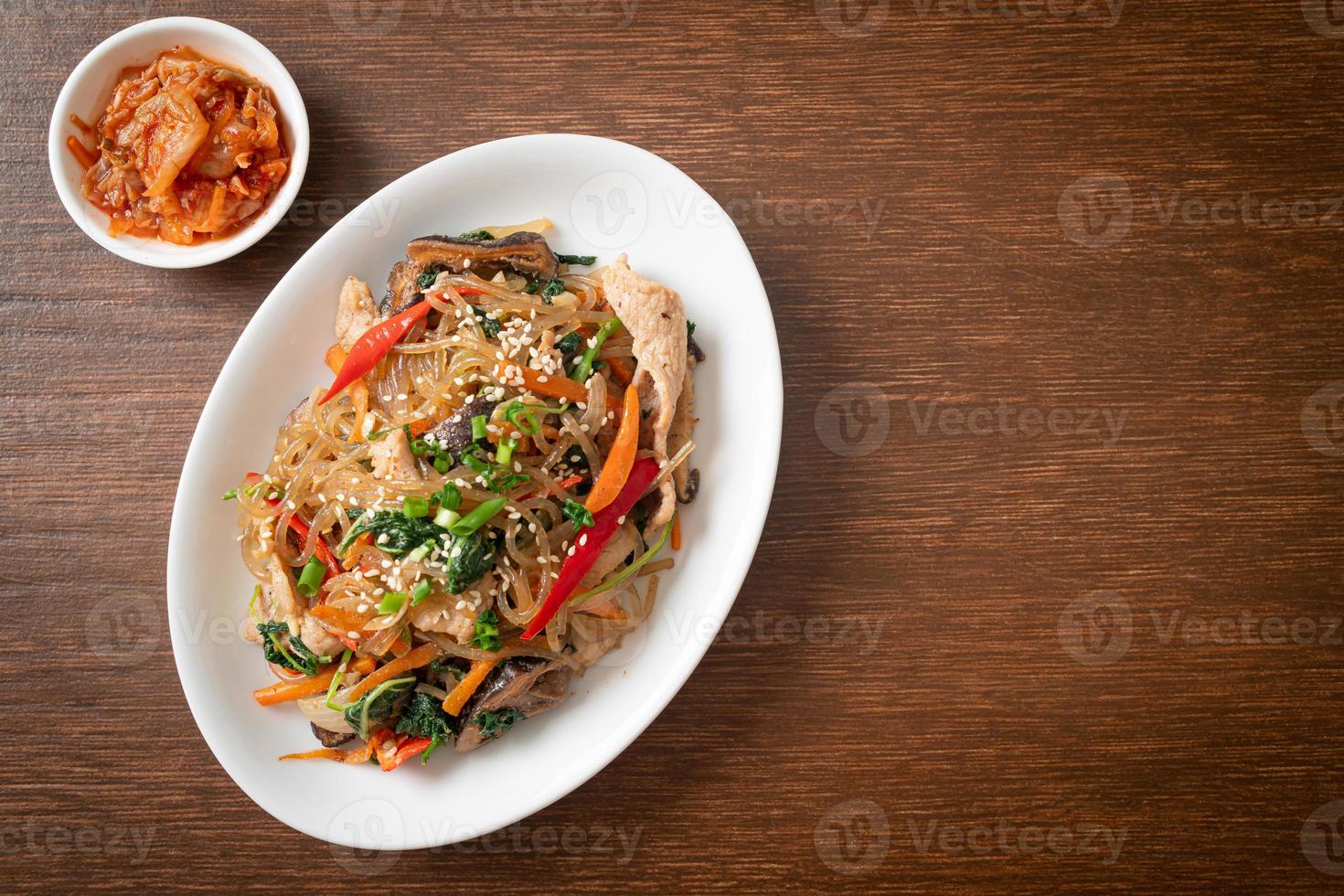 japchae o fideos de fideos coreanos salteados con verduras y carne de cerdo con sésamo blanco foto