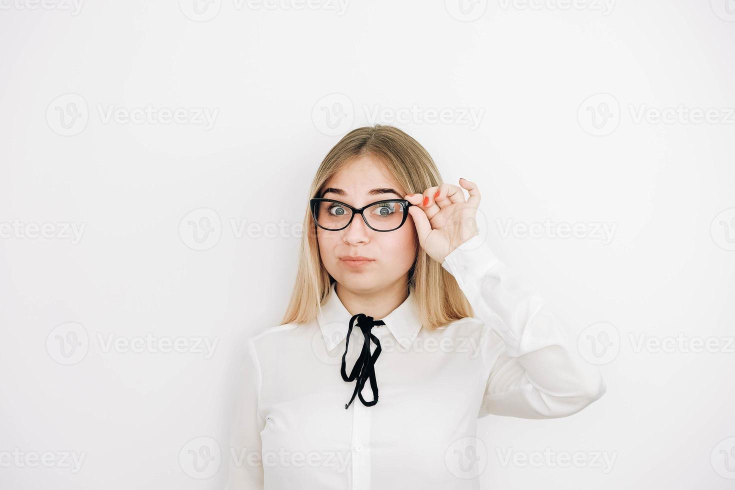 retrato de una hermosa mujer rubia positiva con un elegante pantalones blanco sosteniendo sus gafas sobre un fondo blanco. copiar, espacio vacío para texto foto