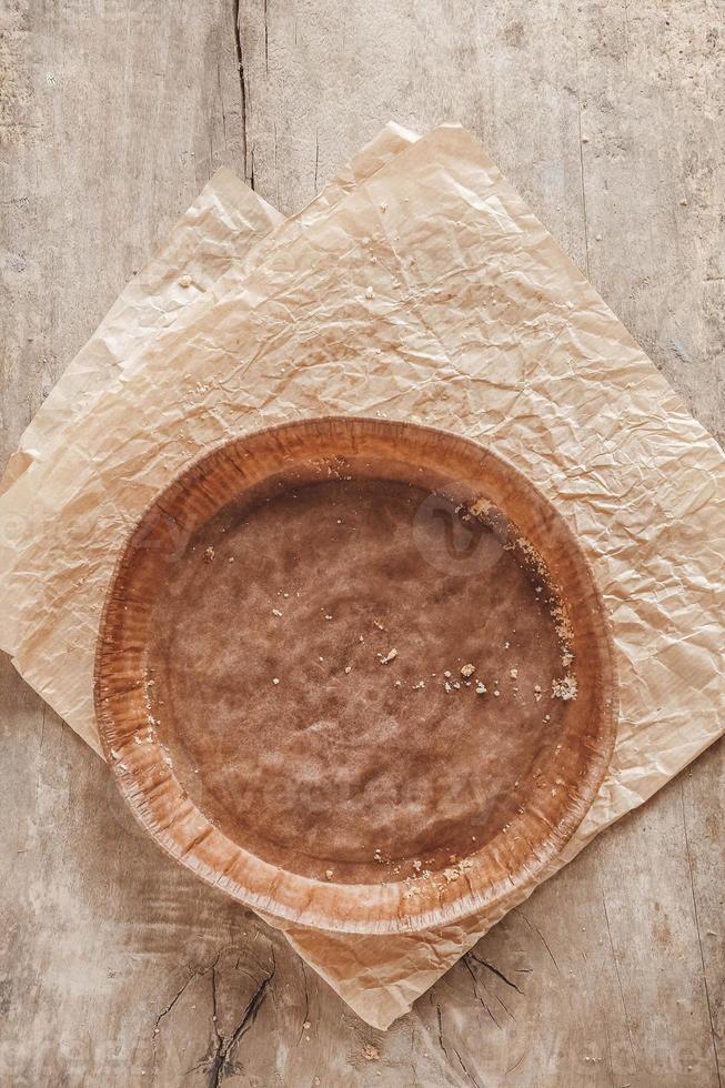 Paper craft plate with crumbs on vintage wooden background texture. Top view. Copy, empty space for text photo