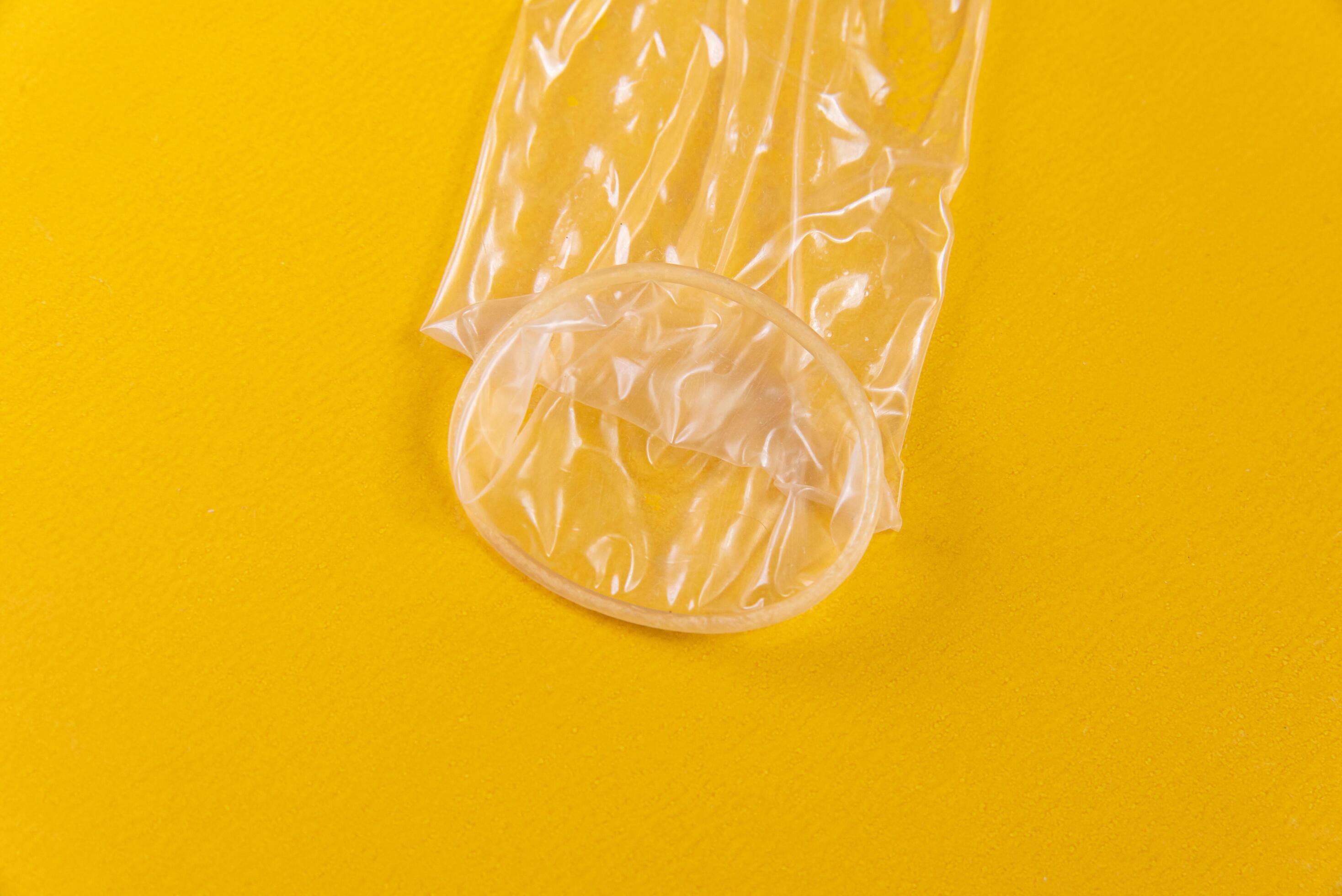 Latex condom on yellow background 5274756 Stock Photo at Vecteezy