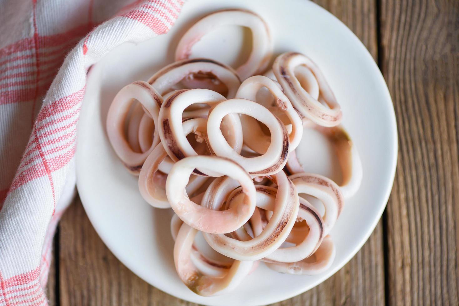 squid rings on white plate, Fresh squid cooked boiled with for food salad on wooden background photo