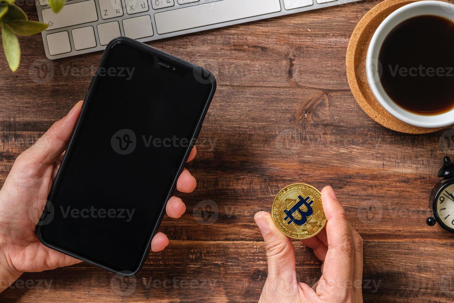hand holding mobile and  bitcoin crypto currency to trading in stock market.defi on blockchain photo