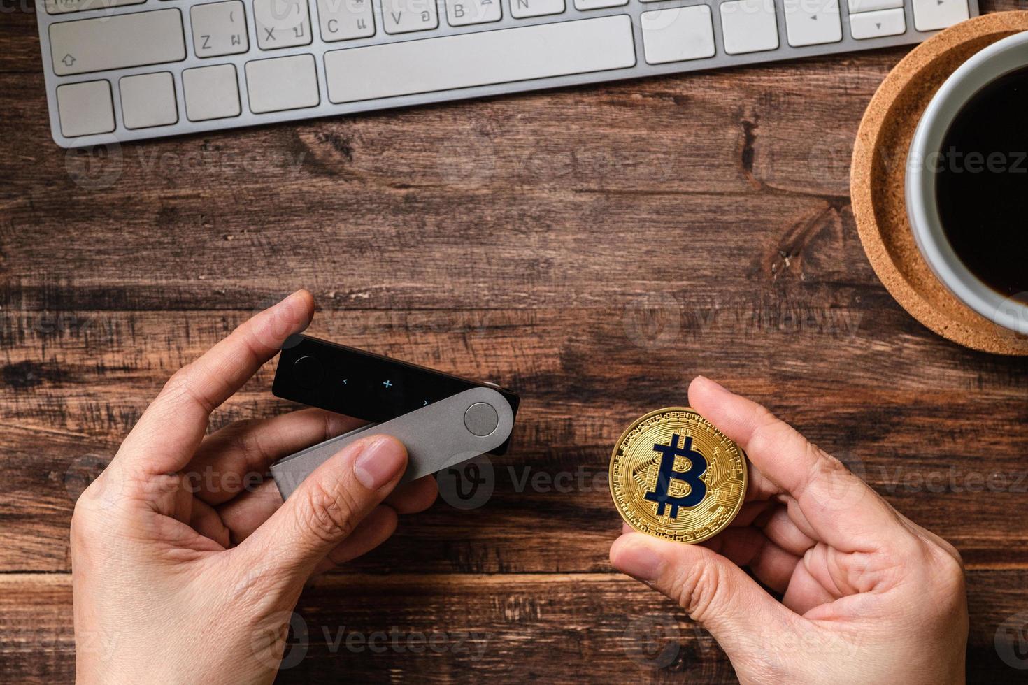 hand holding hardware wallet and transfer bitcoin and ethereum crypto currency to wallet for safety photo