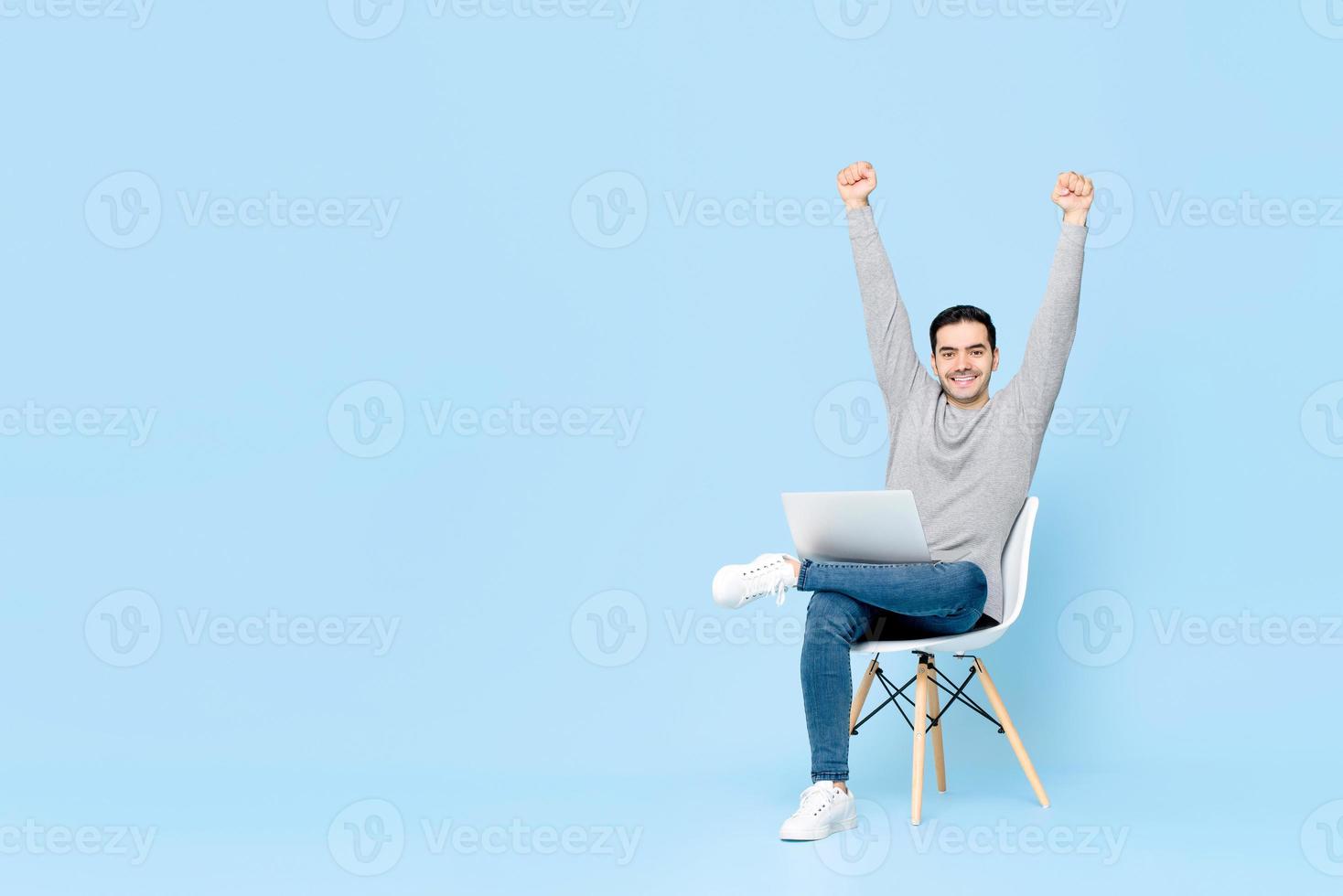 Portrait of happy young handsome Caucasian man sitting using laptop ...