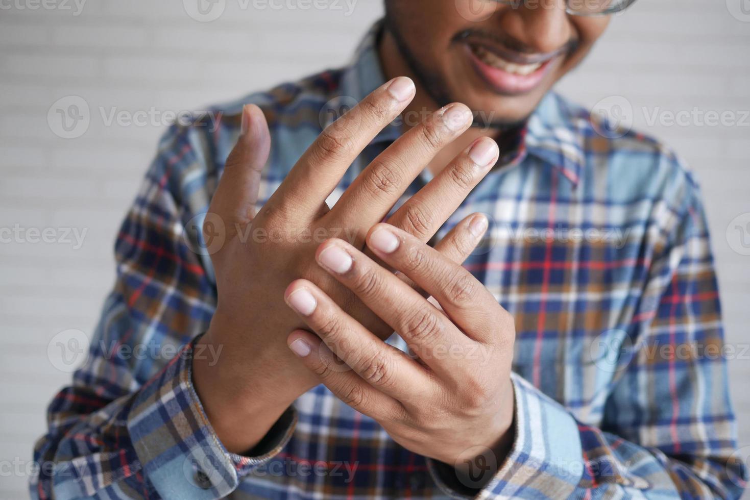 man suffering pain in hand close up photo