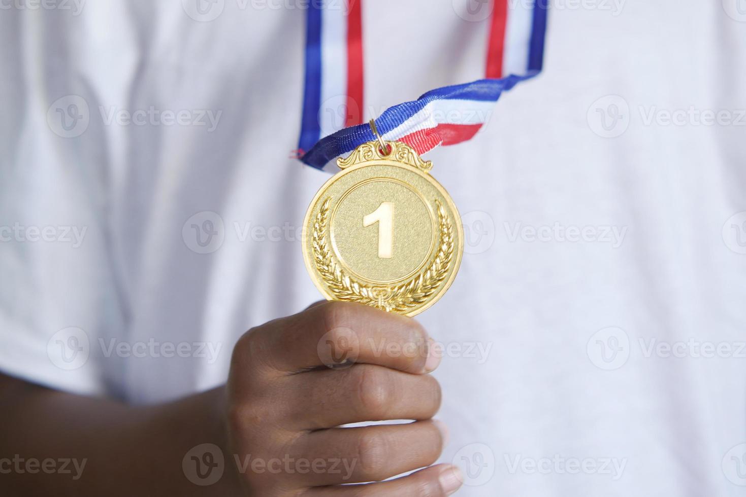 niño sosteniendo el trofeo del primer lugar contra el fondo amarillo foto