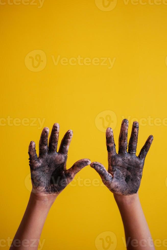 mano sucia con tierra sobre fondo amarillo foto