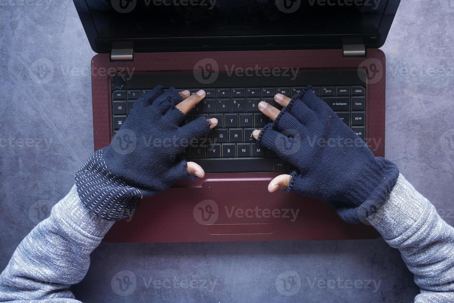 hacker hand stealing data from laptop top down photo