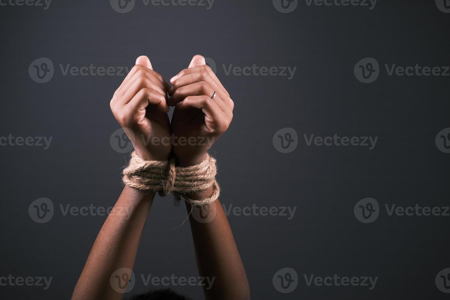 hand tied with rope against black background photo