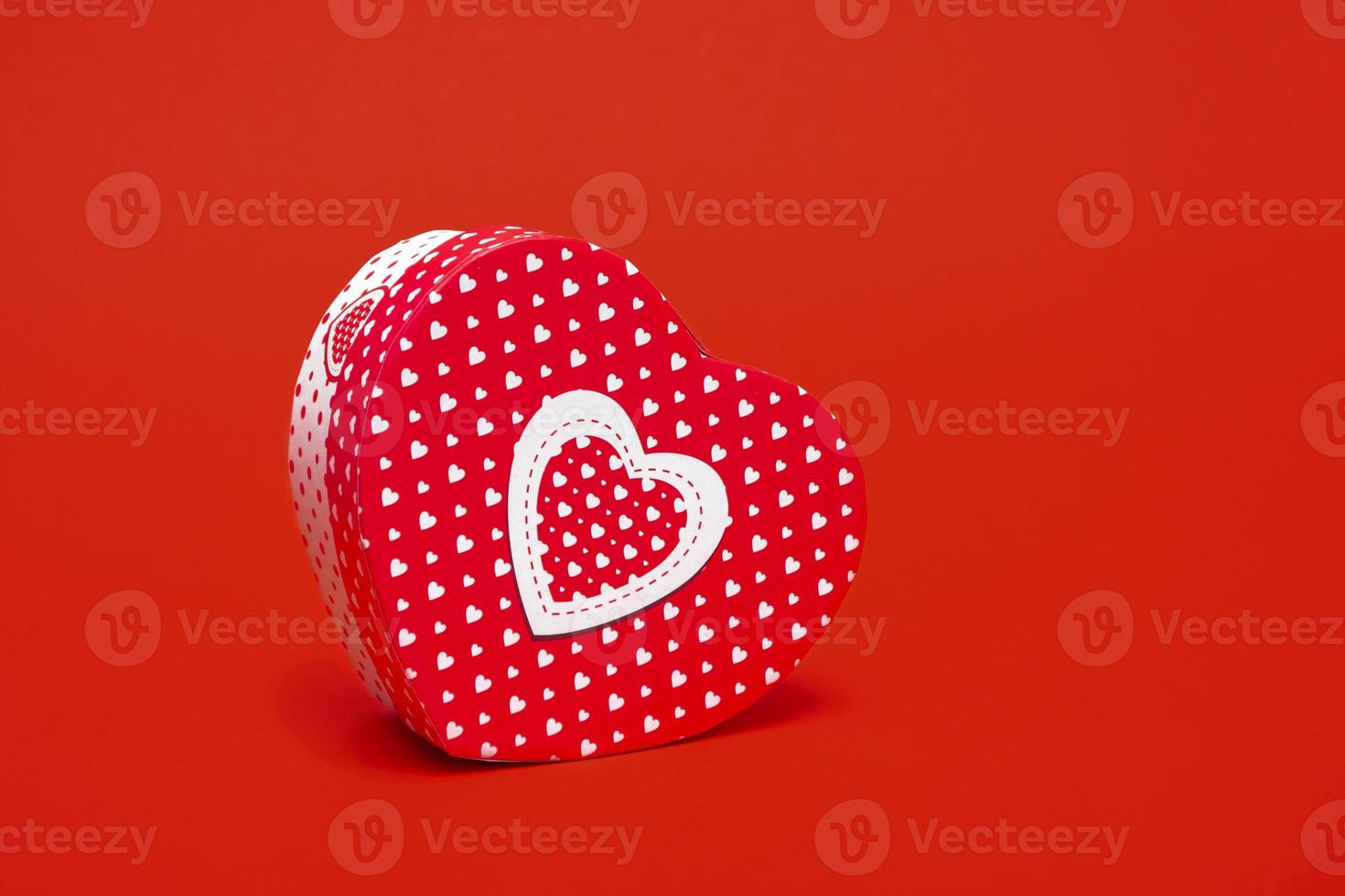 maqueta de una caja en forma de corazón sobre un fondo rojo. primer plano con espacio de copia foto