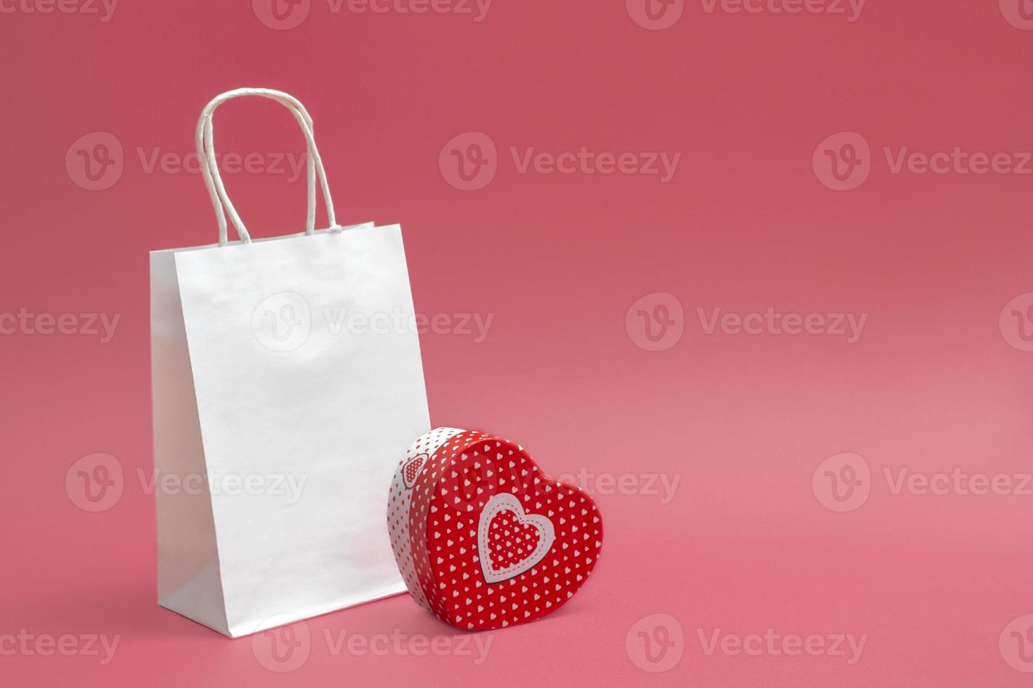 Mockup of craft white bag and heart shaped gift box isolated on white background. Trade idea, sale. Closeup photo