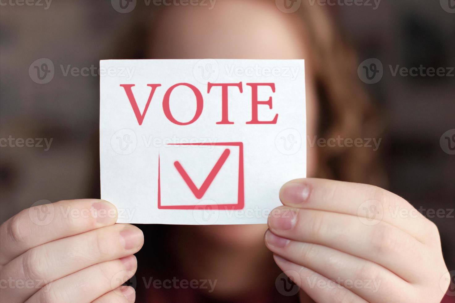 Vote sign in young woman's hands. Voting or making choice concept. photo