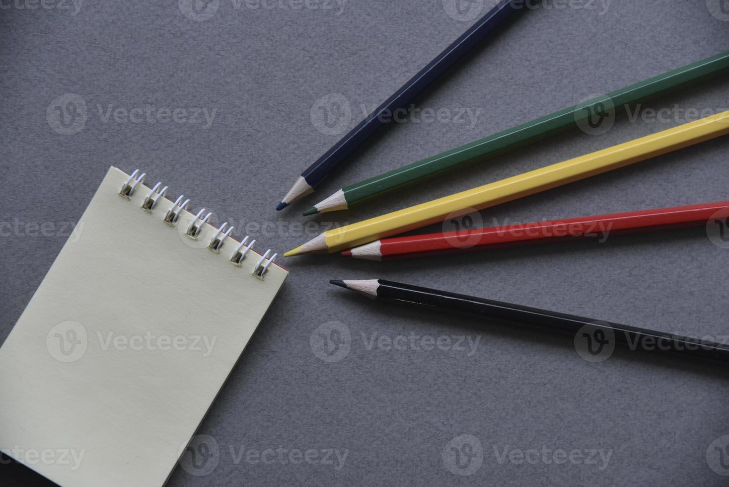 lápices, bloc de notas y clips de papel en el escritorio de la oficina foto