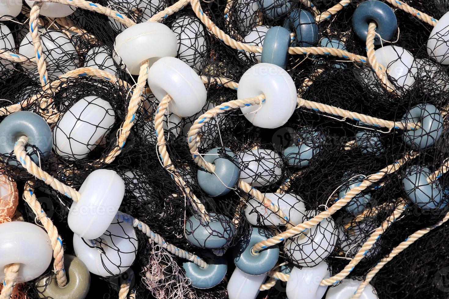 Mixed up fishnet with rope and lot of buoys texture, Nautical marina background. photo