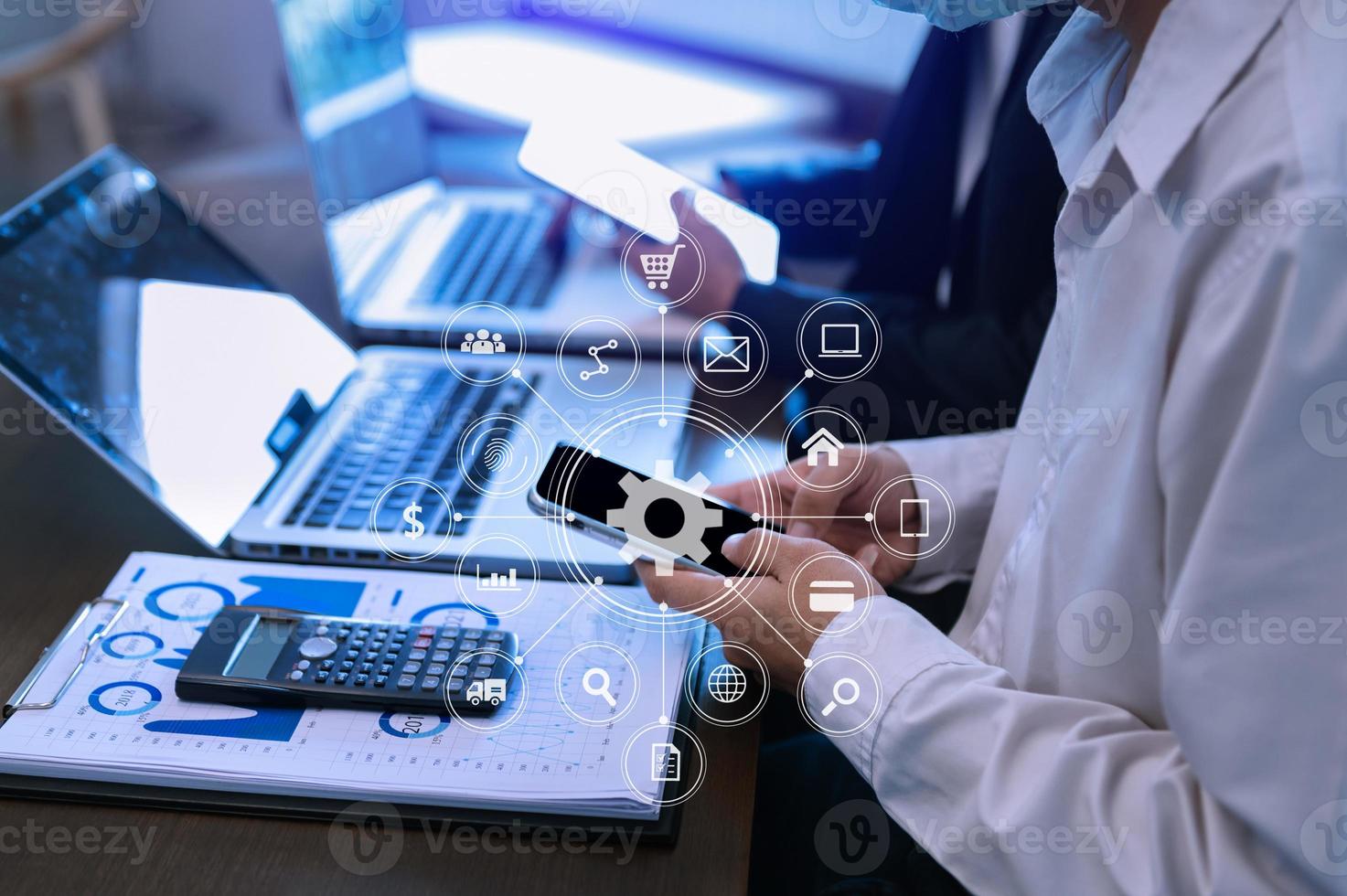 Businesswoman using mobile phone and laptop computer on white desk big data analytics with business intelligence concept. with VR chart and graph photo