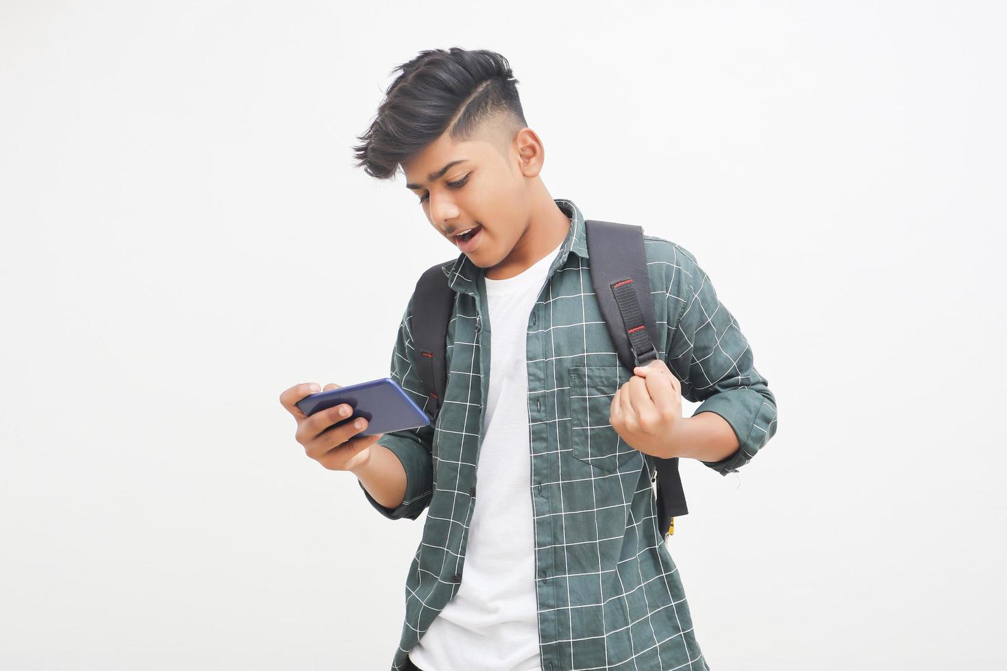 Indian college student using smartphone on white background. photo