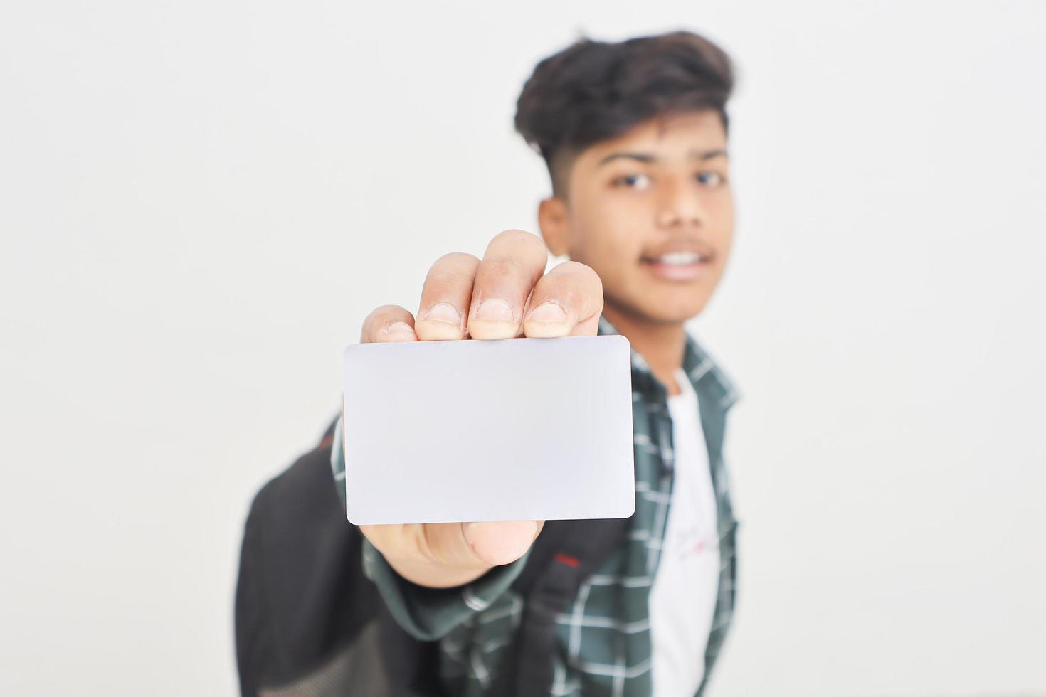 Young indian man showing debit or credit card on white background. photo