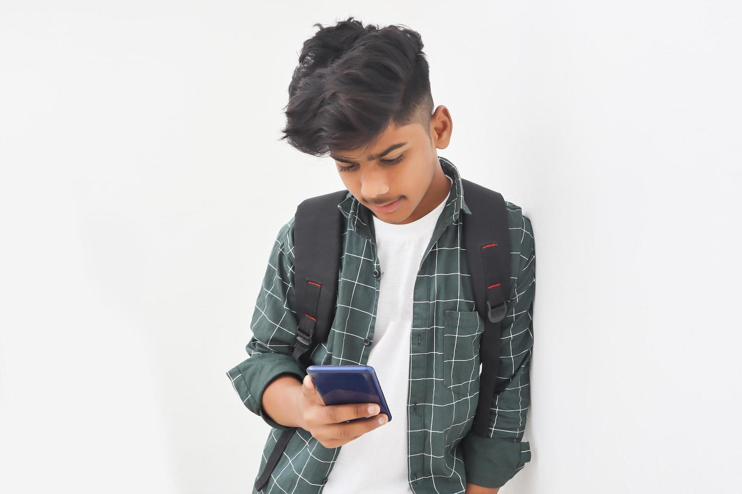 Indian college student using smartphone on white background. photo