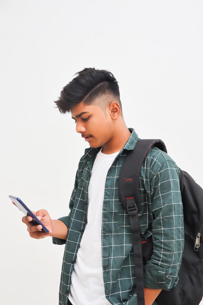 estudiante universitario indio usando un teléfono inteligente con fondo blanco. foto