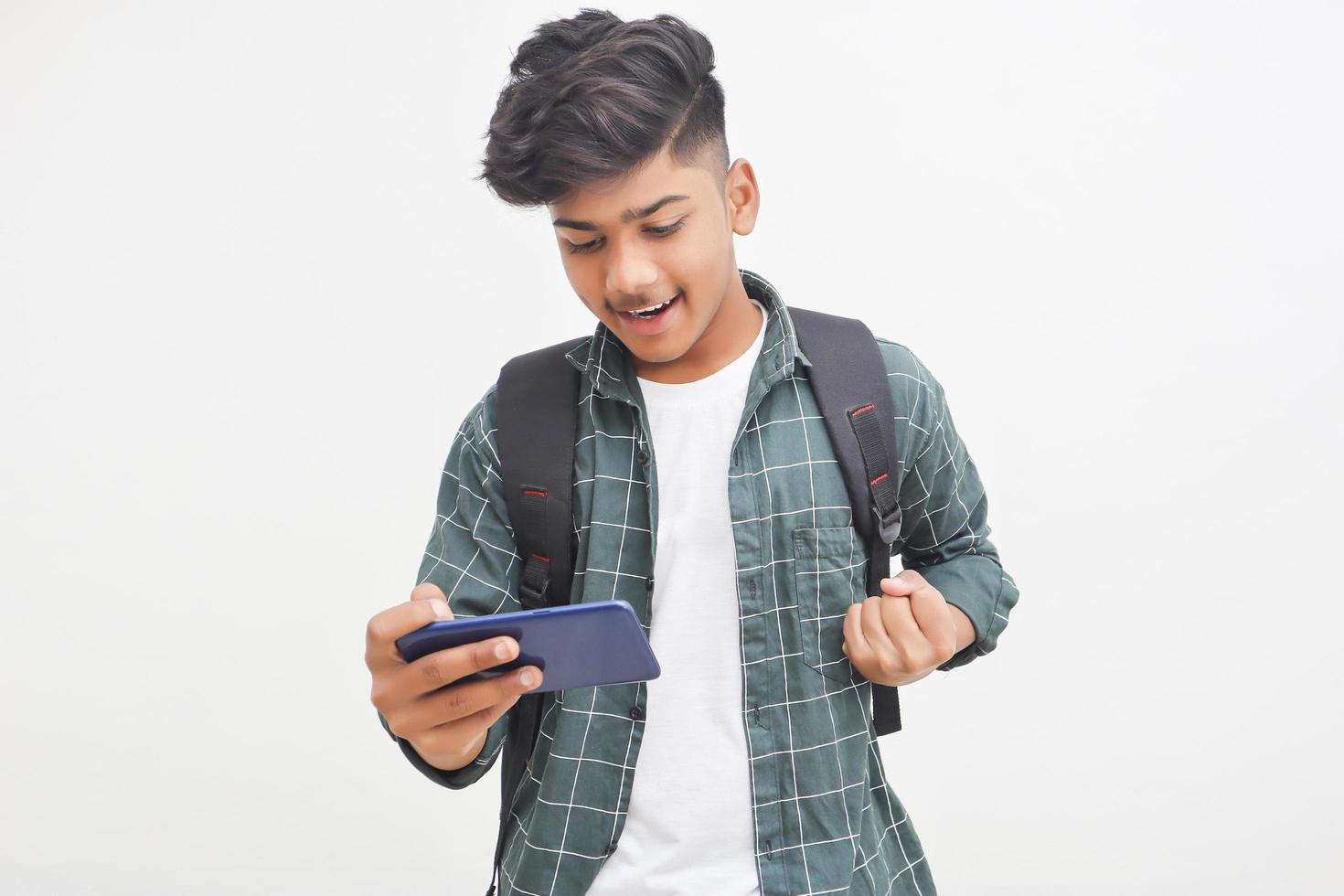 Indian college student using smartphone on white background. photo
