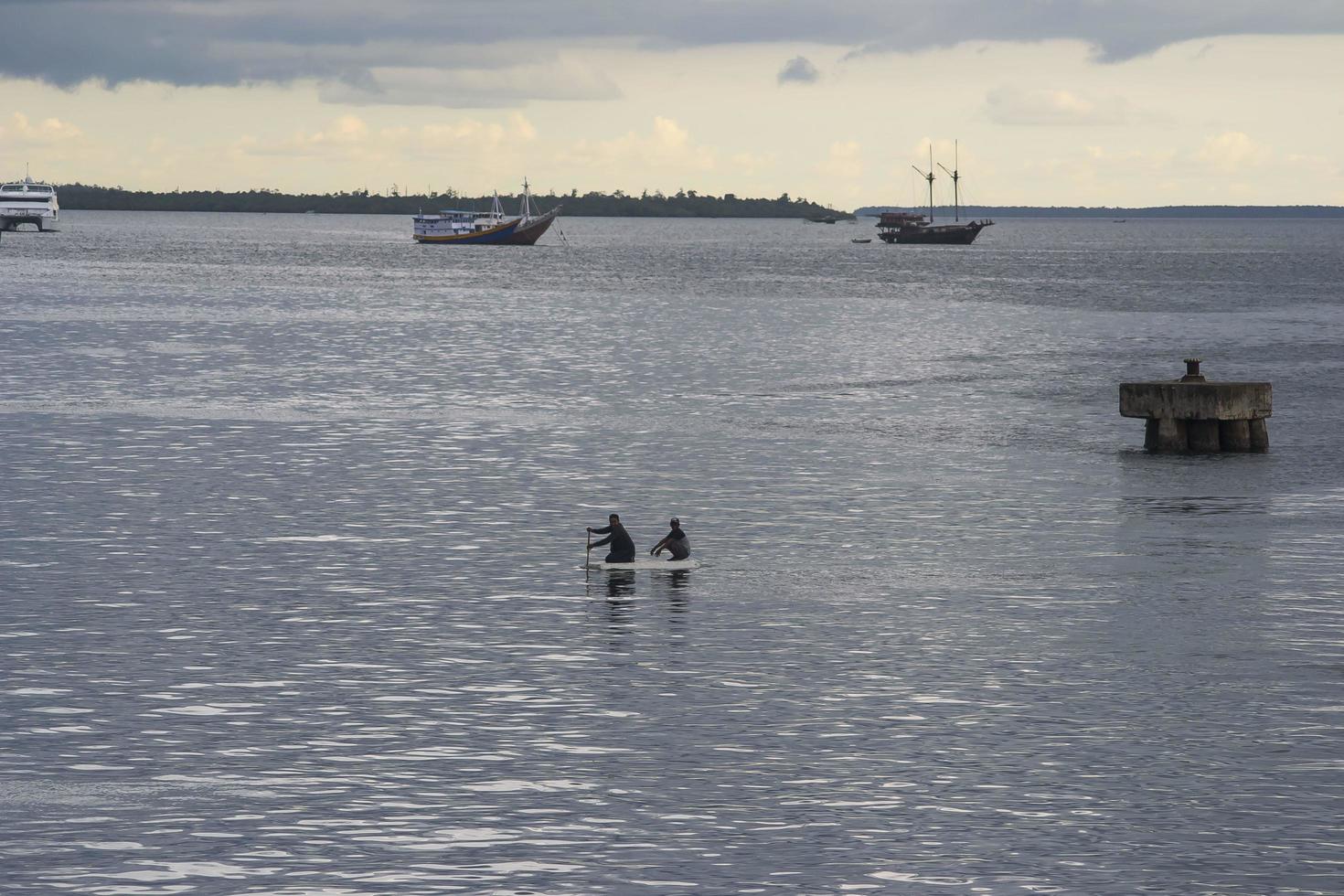 Sorong, West Papua, Indonesia, September 30th 2021. Villagers use styrofoam to cross the sea photo