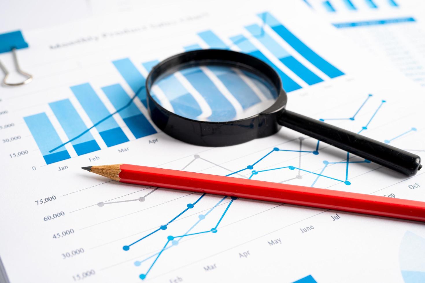 Magnifying glass on charts graphs paper. Financial development, Banking Account, Statistics, Investment Analytic research data economy, Stock exchange trading, Business office company meeting concept. photo