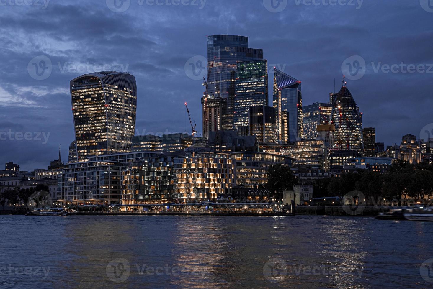 Modern urban skyscrapers lights mirroring in river water photo