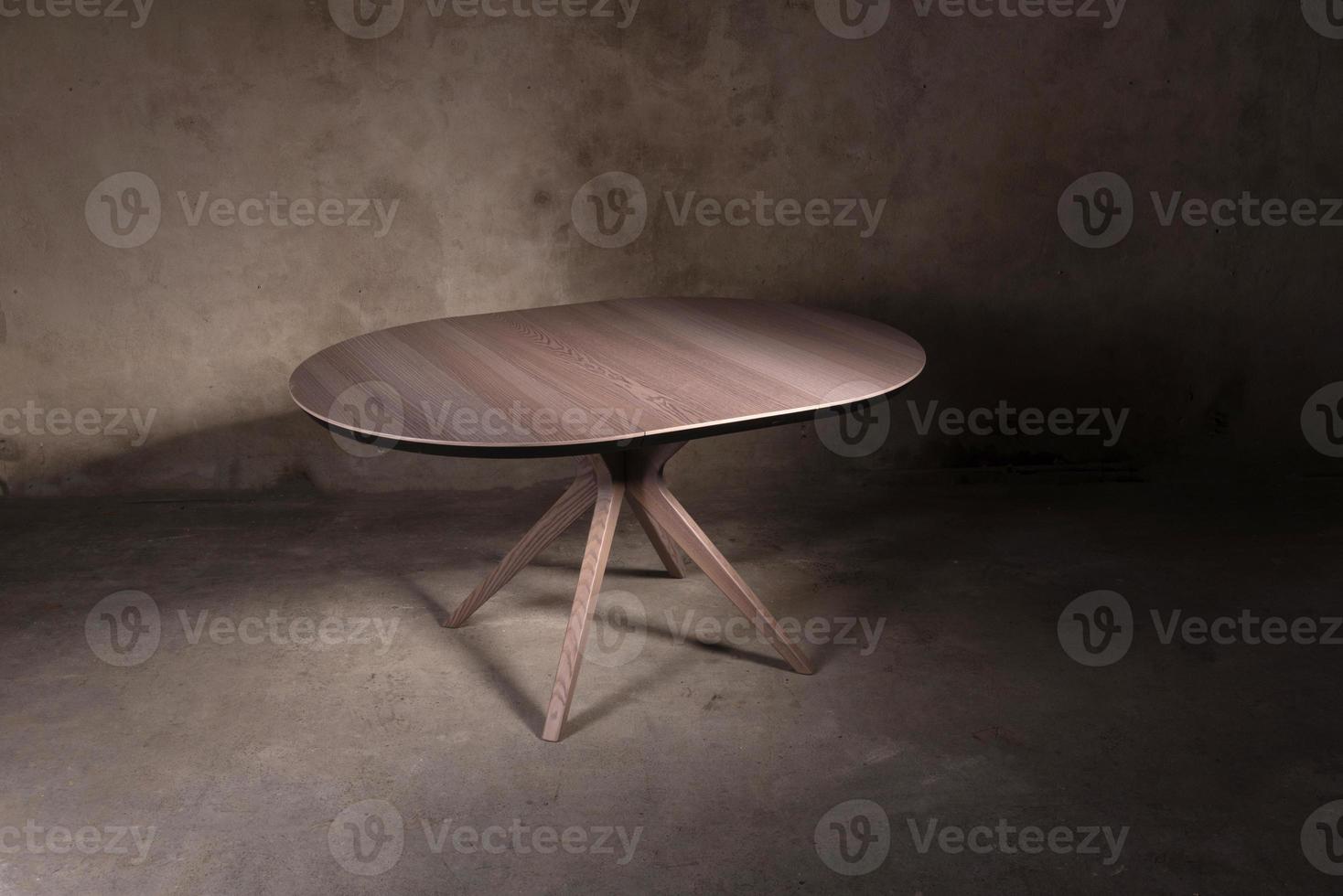 Beautiful brown wooden folding table on beige concrete background photo