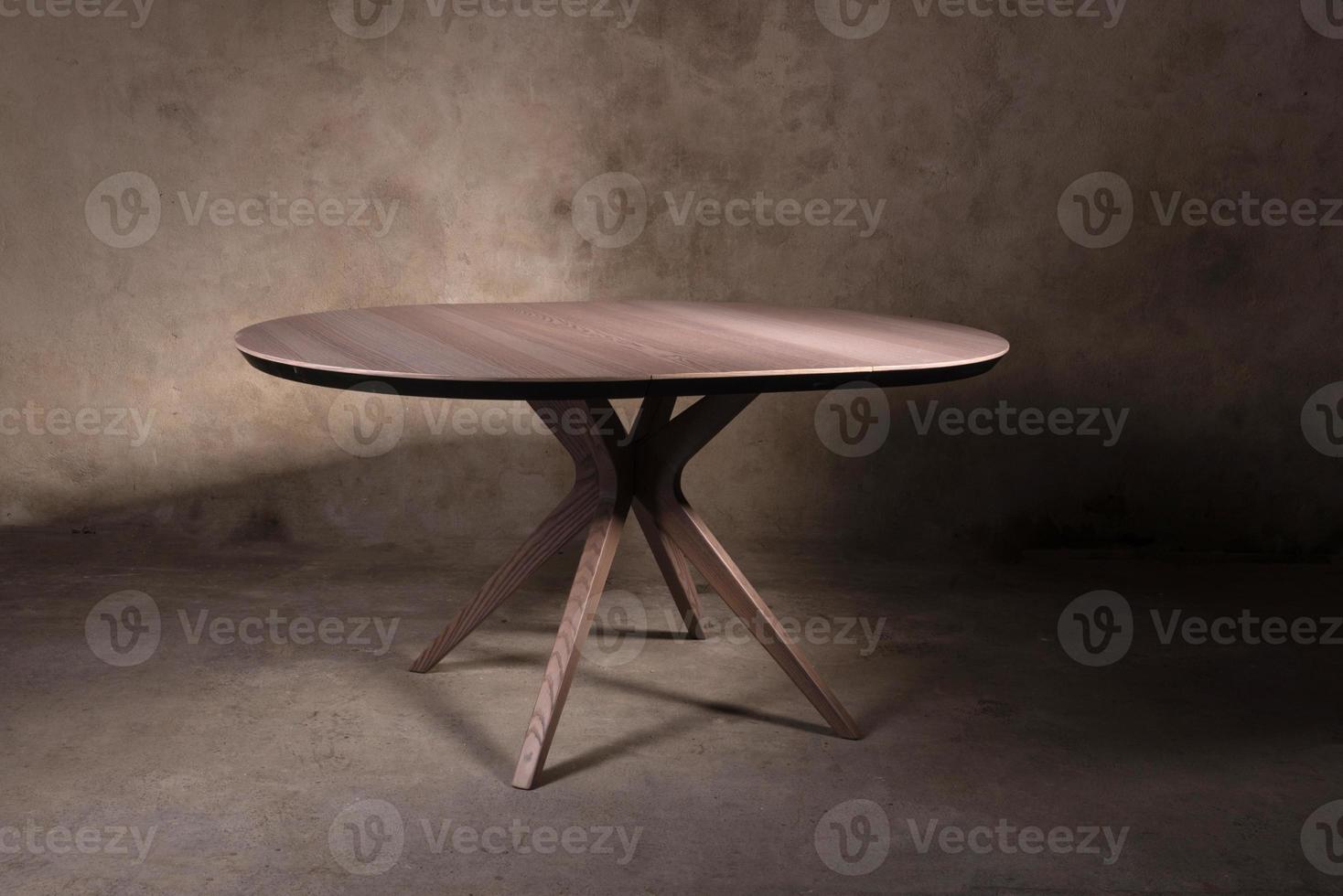Beautiful brown wooden folding table on beige concrete background photo