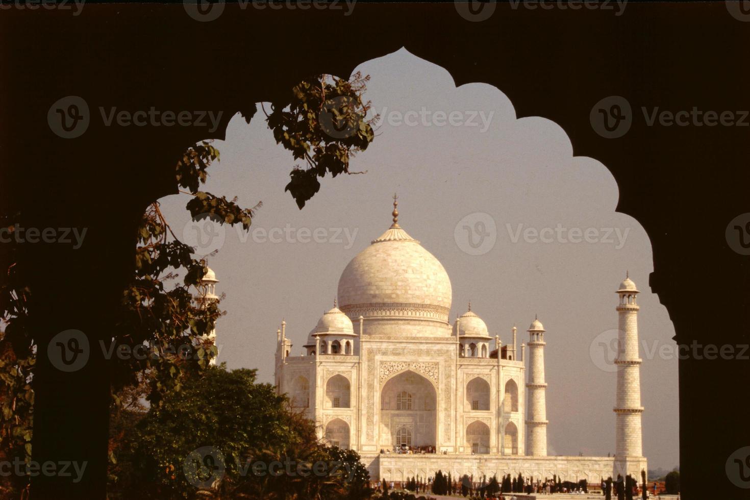 Dark arched frame to magnificent marble edifice Taj Mahal photo