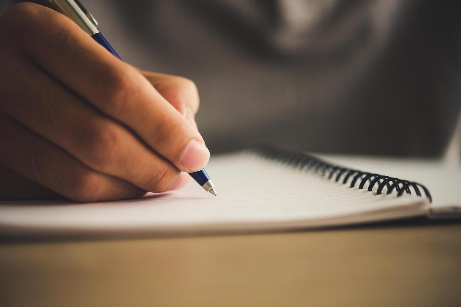 Man hand with pen writing on notebook. photo