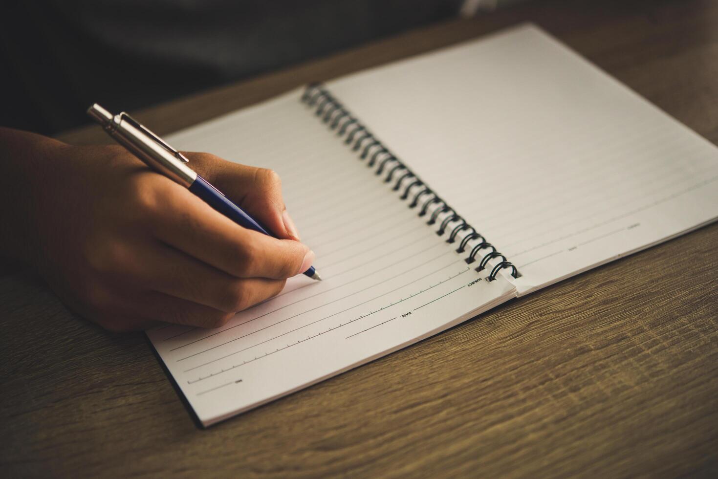 Man hand with pen writing on notebook. photo