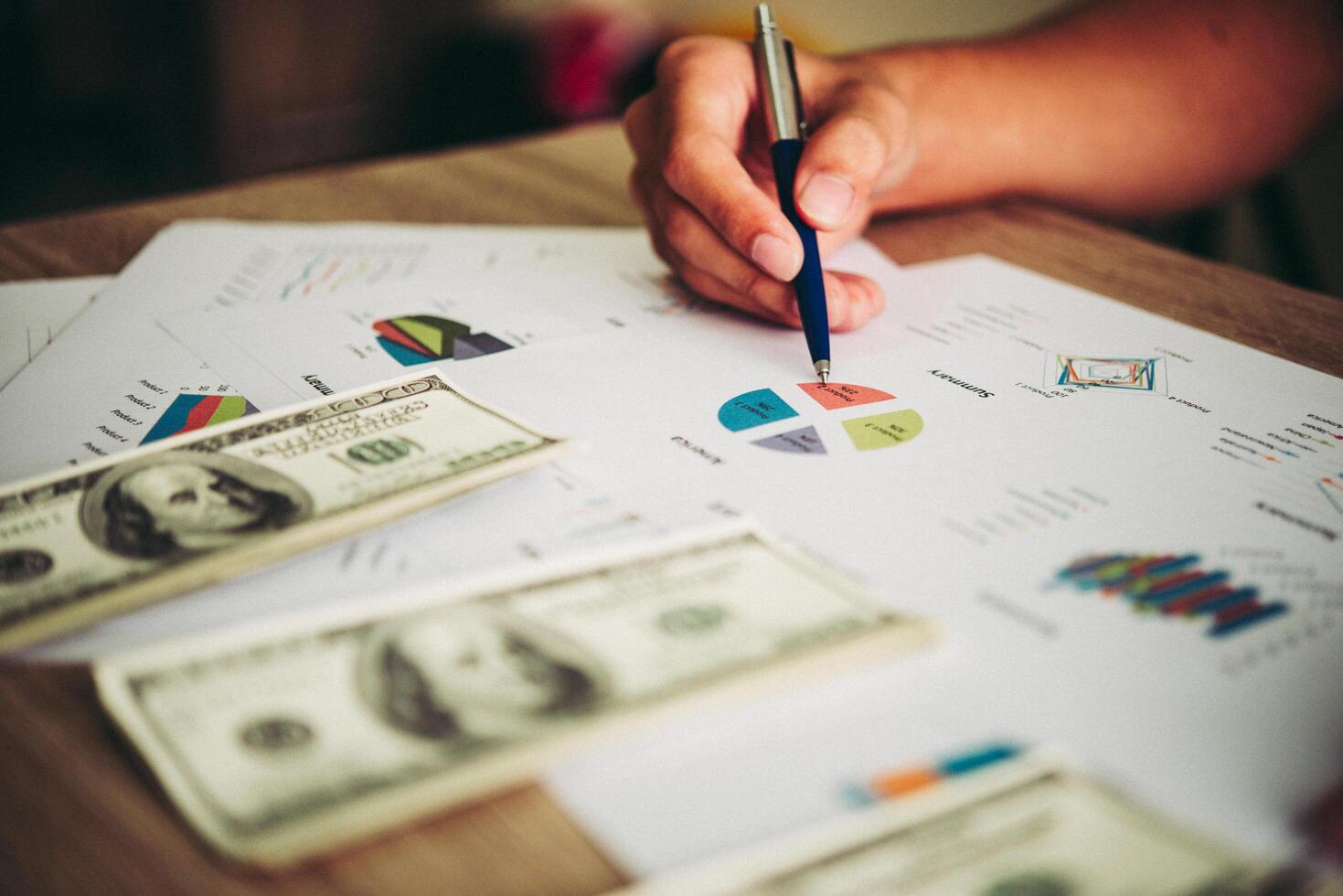 Working place of trader. The table covered by cash notes, keyboard and financial charts. Business financial working. photo
