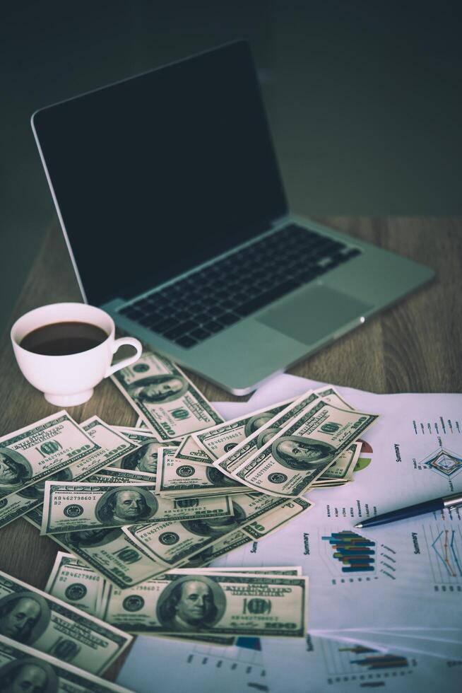 Working place of trader. The table covered by cash notes, keyboard and financial charts. Business financial working. photo