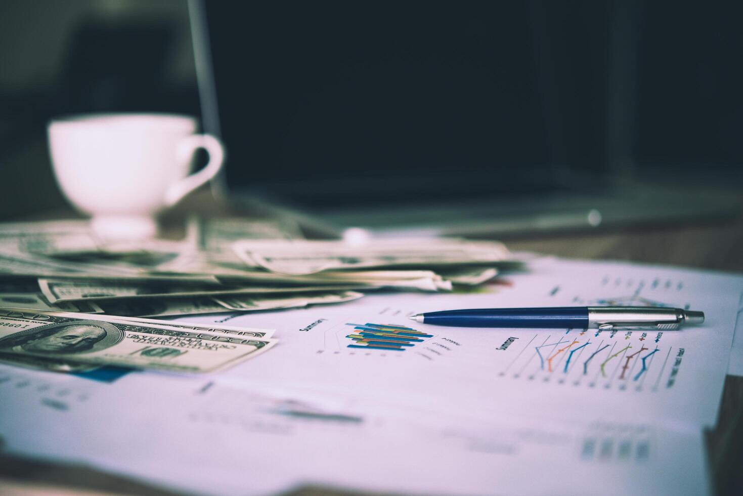 Working place of trader. The table covered by cash notes, keyboard and financial charts. Business financial working. photo