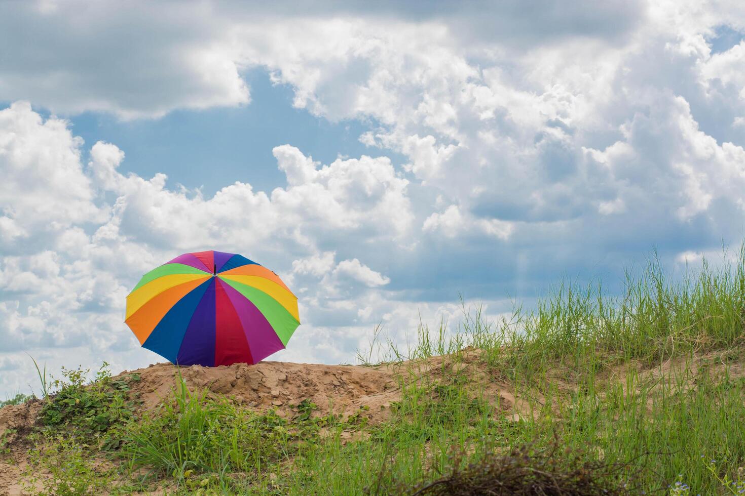 rainbow umbrella resting on the ground photo