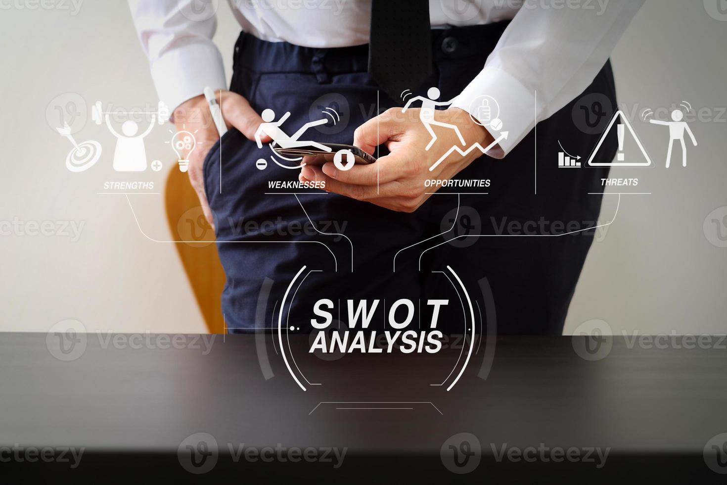 close up of businessman working with smart phone on wooden desk in modern office photo