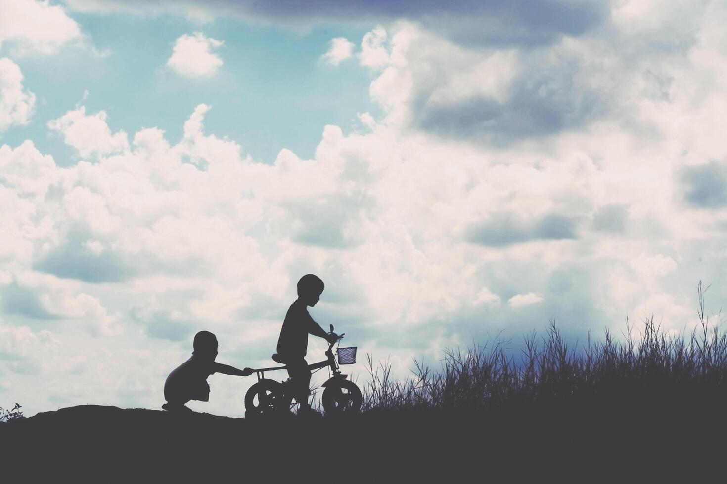 two little boys bike silhouette photo